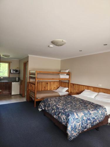 a bedroom with two beds and a kitchen at Kentish Hills Retreat in Sheffield