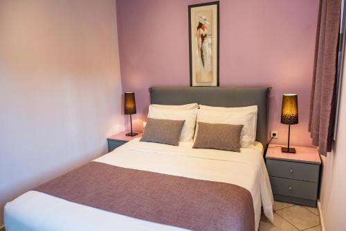 a bedroom with a large bed with two lamps at Cretan Dawn Apart, Value Option in Ammoudara in Ayía Marína