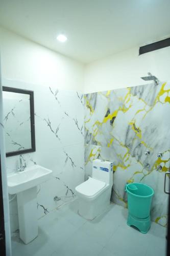 a bathroom with a sink and a toilet and a mirror at Ruchi resort in Hisār