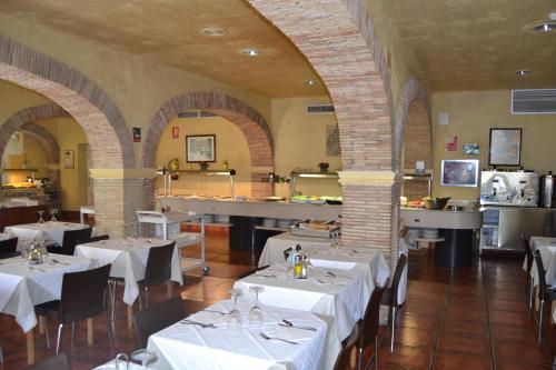 a restaurant with white tables and chairs in a room at Mont-Park in Benidorm