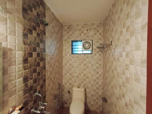 a bathroom with a toilet and a window at Jackfruit in Arambol