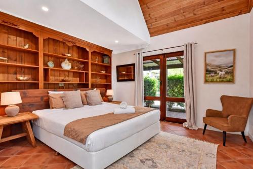 a bedroom with a large bed and a chair at Standen Manor, Hunter Valley Country Estate & Stables in Belford