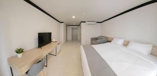 a bedroom with a large bed and a television at Sena House in Bangkok