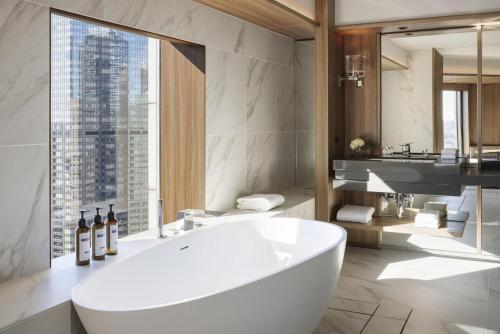 a bathroom with a large white tub and a sink at Hyatt Regency Tokyo in Tokyo