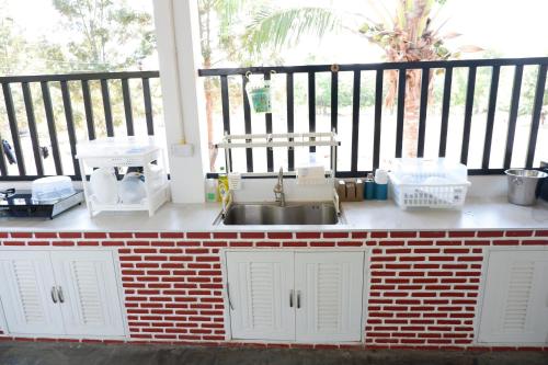 a kitchen counter with a sink and baskets on a balcony at Pran Botanica Private Pool Villa in Ban Rom Pho