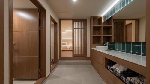 a bathroom with a sink and a mirror at Maison The Denbasta Hotel in Busan