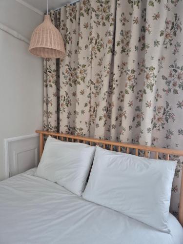 a bed with white pillows in a bedroom with a curtain at 어게인수영 in Suyŏng