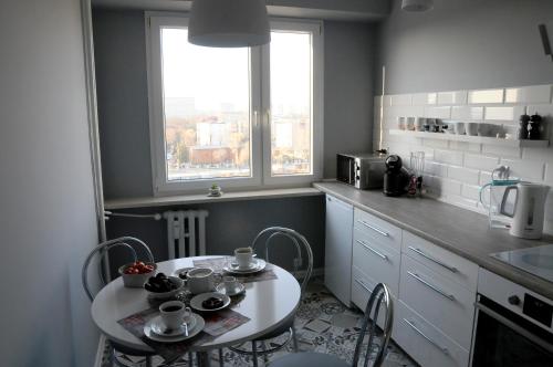a kitchen with a table and chairs in a kitchen at Apartament Kiza in Kielce