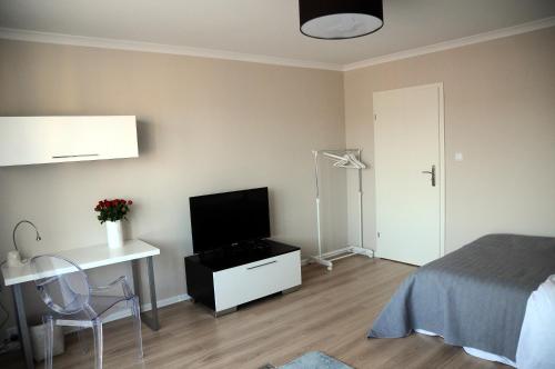 1 dormitorio con 1 cama y escritorio con TV en Apartament Kiza, en Kielce