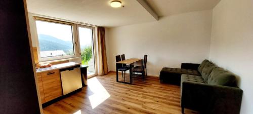 a living room with a couch and a table and a window at Ferienwohnung Sonnenschein in Balderschwang