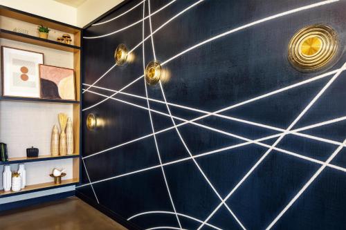a room with a blue wall with white lines at Tempo By Hilton Manassas in Manassas