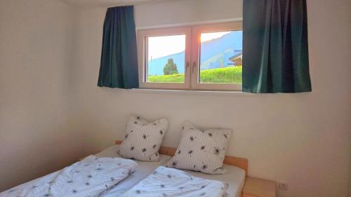 a bedroom with two beds and a window at Ferienwohnung Sonnenschein in Balderschwang