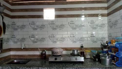 a kitchen counter with a sink and a stove at DSD Bomzon Homestay in Darjeeling