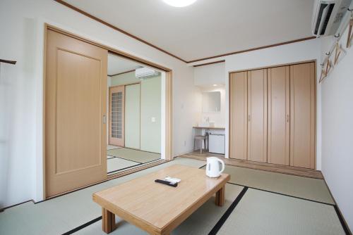 a room with a wooden table and a mirror at レインボーマリン in Mihama