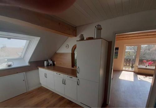 a kitchen with a white refrigerator and a window at Ferienwohnung Lechauszeit in Landsberg am Lech