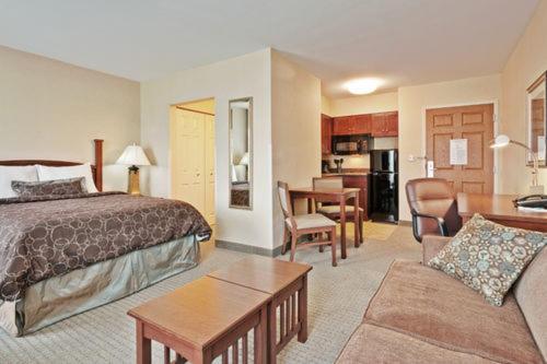 a hotel room with a bed and a living room at Staybridge Suites Williamsville Buffalo by IHG in Williamsville