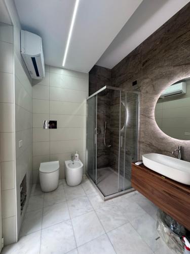 a bathroom with a sink and a shower and a toilet at Dejavu ROOMS & SPA in Assoro