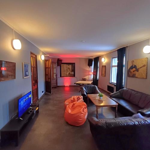 a living room with couches and a tv and a table at Objekts Guesthouse - Creative Quarter Apartment in Riga