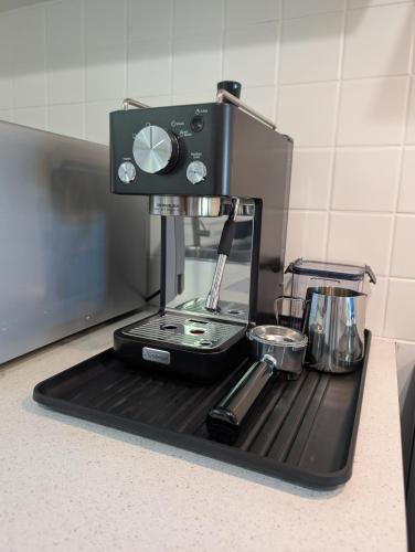 a coffee maker on a black tray on a kitchen counter at Healesville Schofield Cottage in Healesville