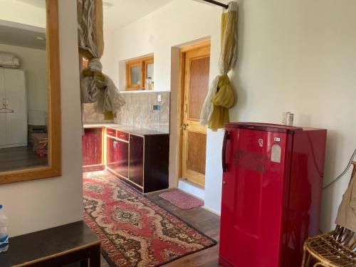 a kitchen with a red refrigerator in a room at Hotel Latso Ladakh in Leh