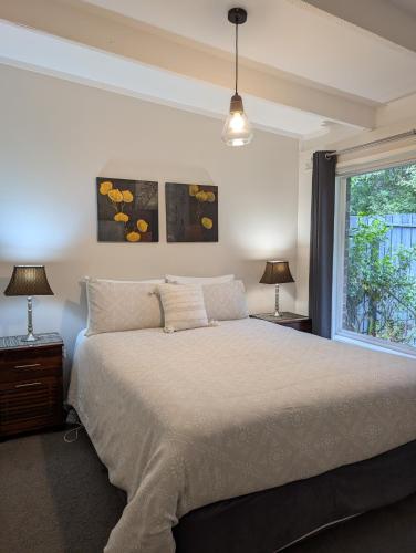 a bedroom with a large bed and a window at Healesville Schofield Cottage in Healesville