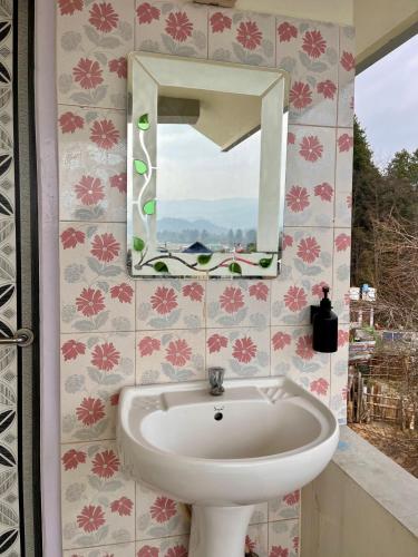 a bathroom with a sink and a mirror at Yogstel - Backpackers Hostel in Dūta