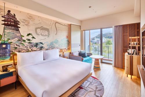 a hotel room with a bed and a large window at Hotel Indigo Inuyama Urakuen Garden by IHG in Inuyama