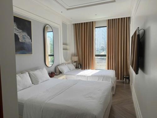 a hotel room with two beds and a large window at Phúc Thắng Hotel in Phú Quốc