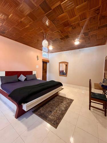 a bedroom with a large bed and a wooden ceiling at Yogstel - Backpackers Hostel in Dūta
