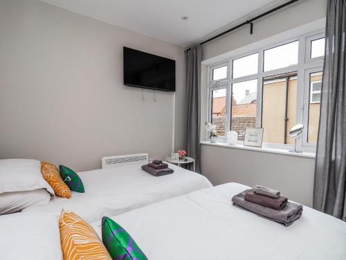 two beds in a room with a window at Brinkleys Nook in Whitby
