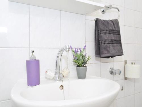 a bathroom sink with a purple soap dispenser on it at Apartment T&M in Trogir