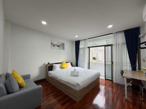 a bedroom with a bed and a couch at S Hostel Sukhumvit 48 in Bangkok
