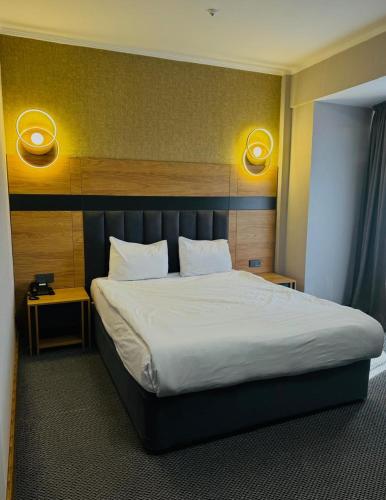 a bedroom with a large bed with white sheets at Golden Palace Hotel in Almaty