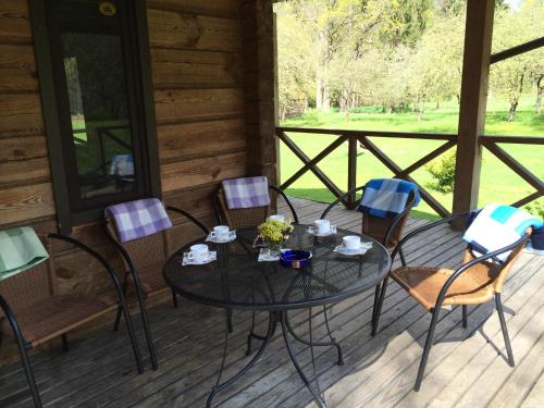 a table and chairs on the porch of a cabin at Sodyba Duburiai in Ukmergė