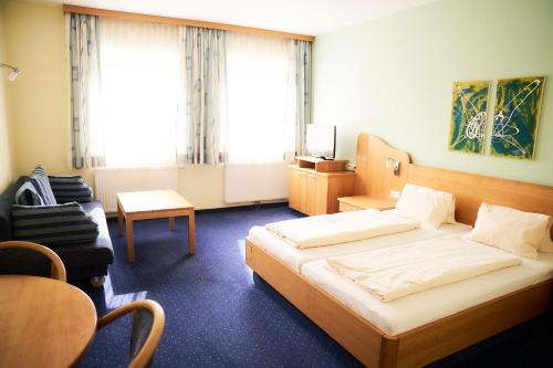 a hotel room with a bed and a chair at Gasthof Hotel Lang in Rauchwart im Burgenland