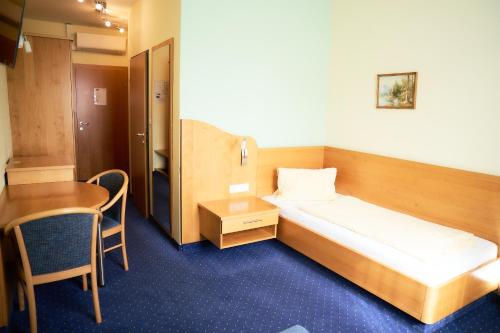 a hotel room with a bed and a table at Gasthof Hotel Lang in Rauchwart im Burgenland