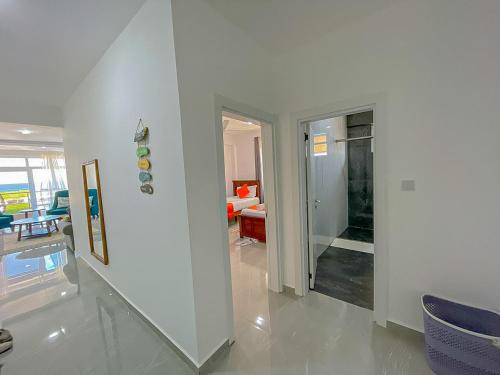 a living room with white walls and blue chairs at Aqua seaside Apartments in Mombasa