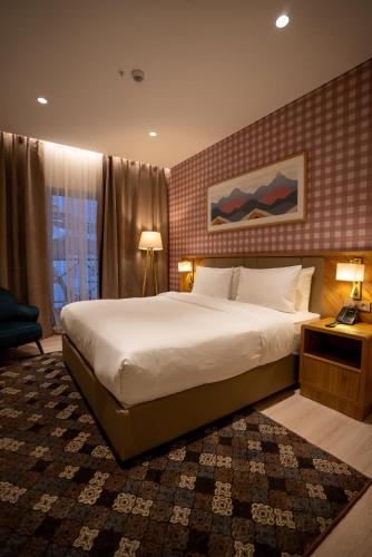 a hotel room with a large bed and a window at Zafaron Premium Hotel in Chimgan