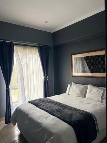a bedroom with a large bed and a window at Tranquil Arcade in Boschrand