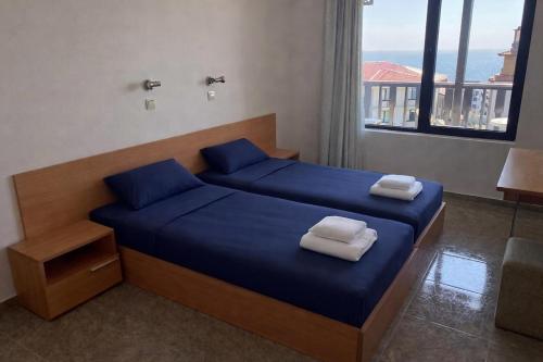 a bedroom with a bed with blue sheets and towels at Stylish, 1-Bedroom at Watermill Complex in Bŭnzareto