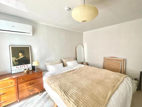 a bedroom with a bed and a wooden dresser and a bed sidx sidx sidx at Gold Stream House in Seoul