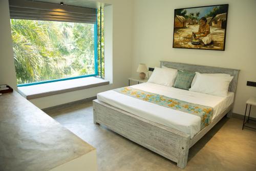 a bedroom with a large bed and a window at KAHA by TONIK, Talpe - Pool & Garden in Talpe