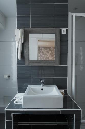 a bathroom with a white sink and a mirror at Hotel Cosmos in Paris