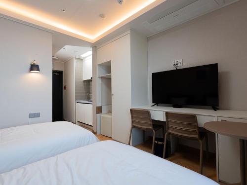 a hotel room with a desk with a flat screen tv at 블루앤호텔 in Songjŏng