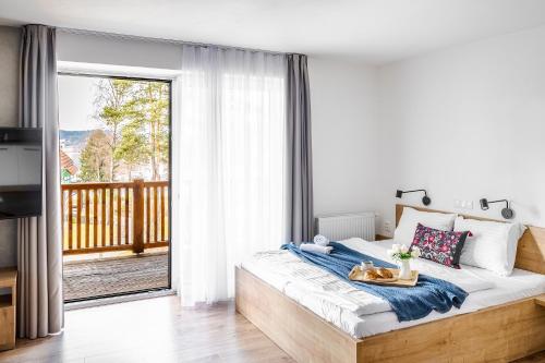 a bedroom with a large bed and a balcony at Jen tak Lipno in Lipno nad Vltavou
