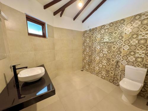 a bathroom with a toilet and a sink at The Dimora Residence in Kurunegala
