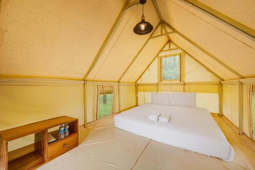 a bedroom with a large white bed in a tent at Phum Domnak Domrey Resort in Chambok