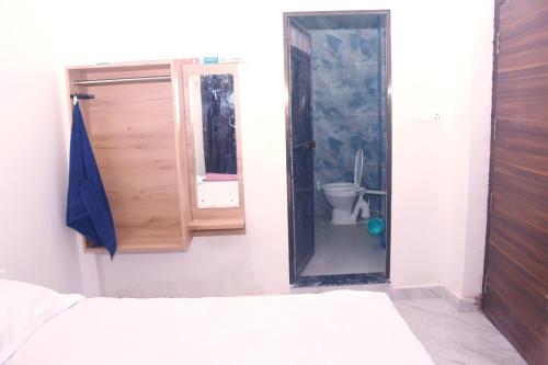 a bedroom with a bathroom with a toilet and a mirror at Privyrooms Taramandal in Gorakhpur