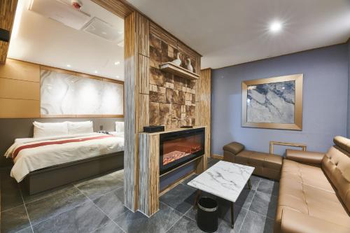 ein Hotelzimmer mit Bett und Kamin in der Unterkunft Aura Tourist Hotel in Ansan