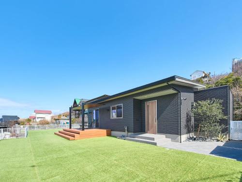 a small house with a yard with a lawn at HUG me Ocean awaji in Sumoto